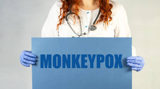 The doctor is holding a blue sheet of paper with the word MONKEYPOX written on it. Doctor's hand in protective gloves with a poster. Layout. Poster. Banner. Warning. Place for text. Virus, epidemic, disease. el médico sostiene una hoja de papel azul con la palabra viruela del sÍmico escrita en ella. mano del médico en guantes protectores con un póster. diseño. póster. estandarte. advertencia. lugar para el texto. virus, epidemia, enfermedad.