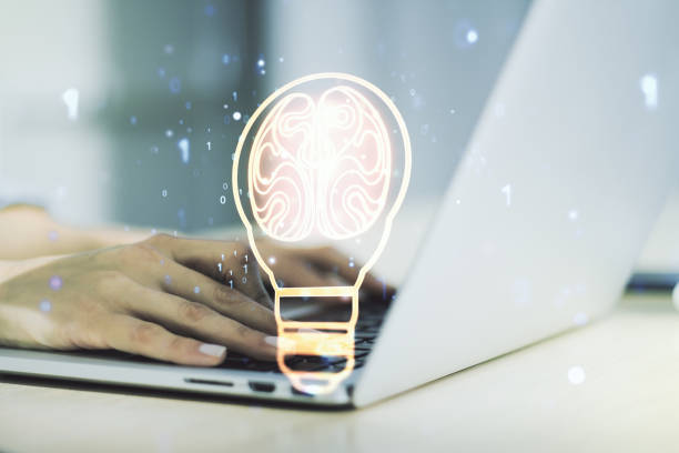 istock Double exposure of creative light bulb hologram with human brain and with hands typing on laptop on background, idea and brainstorming concept 1459003433