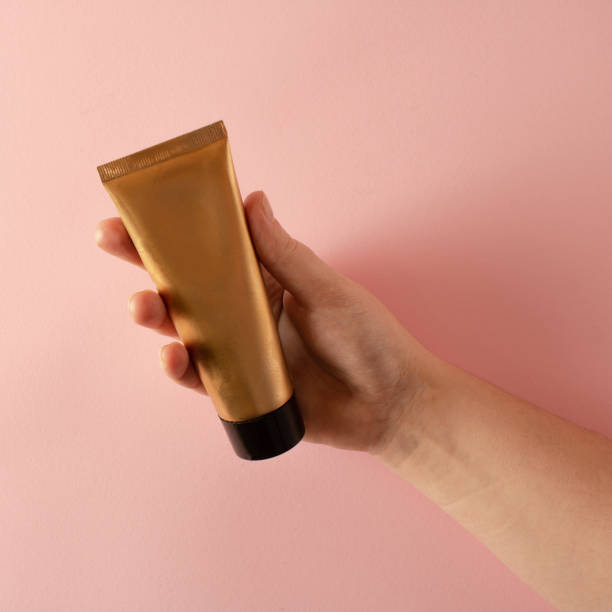 istock Golden hand cream in a woman's hands on a pink background 1459010851