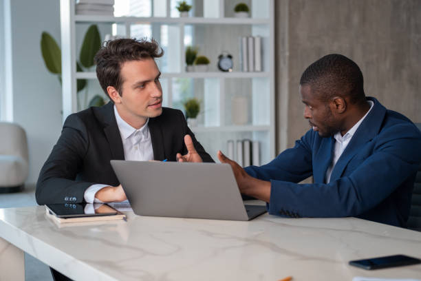 istock Attentive African American businessman talking to colleague explaining project 1459014008