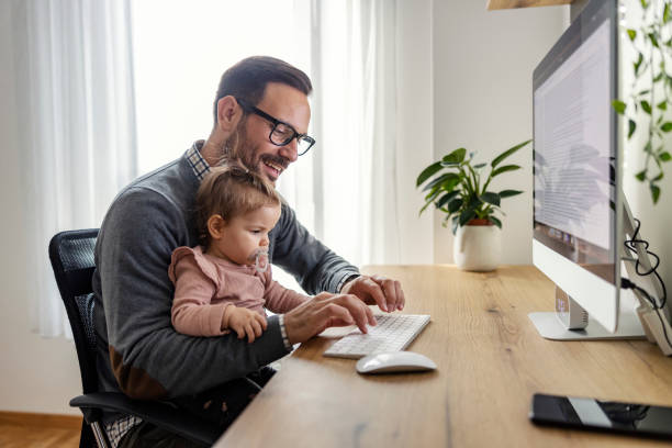 istock A little baby girl helping her busy father with work on computer. 1459014568