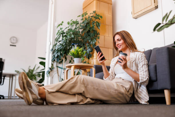 istock Business woman using smart phone while taking a coffee break 1459015347