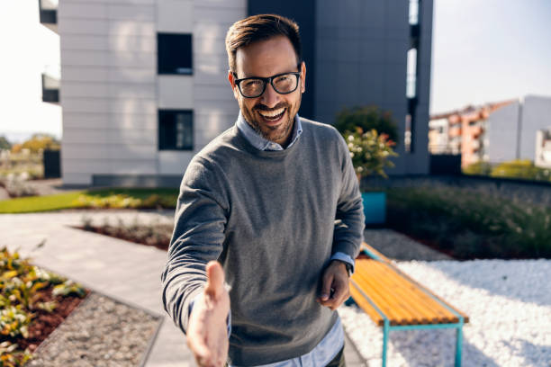 A real estate agent introducing himself on a street downtown. stock photo