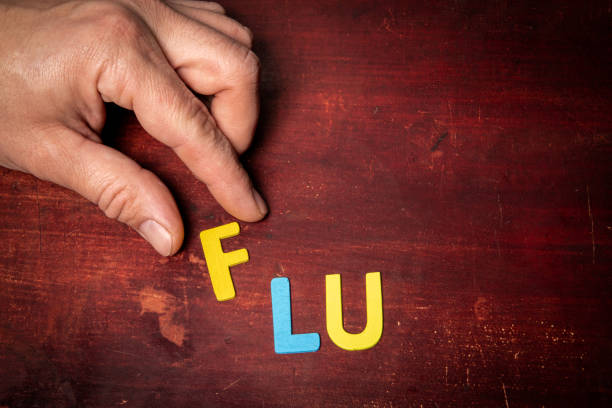 istock FLU Concept. Colorful letters text on wood texture background 1459019137