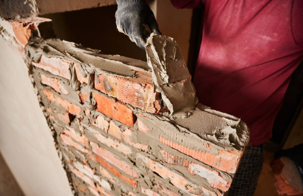 istock Male builder in work gloves building brick wall. 1459019514
