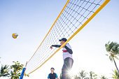 Low angle view of man throwing volley ball over net