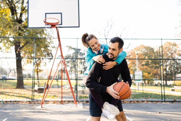 istock Young man carrying his girlfriend and playing basketball with her 1459020421