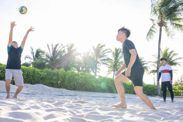 istock Young man kicking volley ball over net, playing at sunrise 1459020552