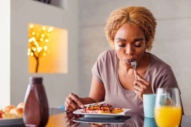Woman having breakfast and relaxing at home in the morning stock photo