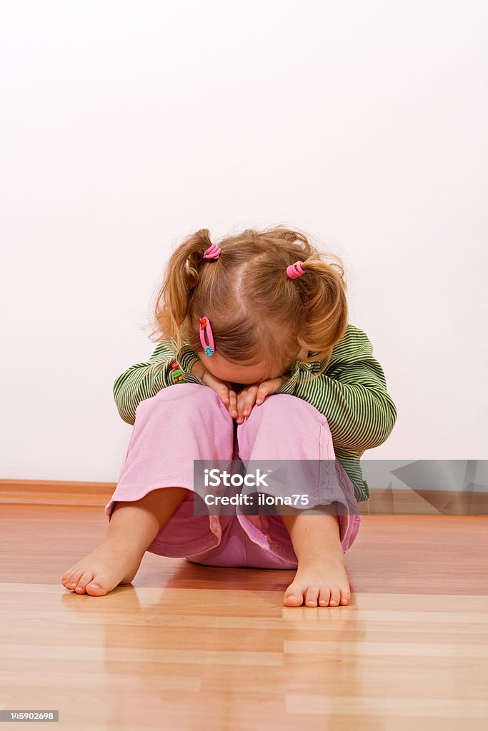 Unhappy baby girl Little girl laying laying had on her knees Anger Stock Photo