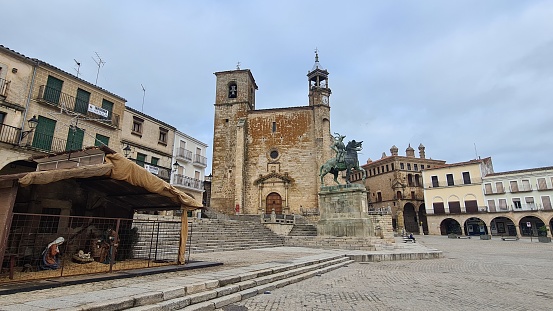 Trujillo, Spain  – December 6, 2022: San Martín de Tours Church and Francisco de Pizarro Statue in Plaza Mayor, Trujillo, Spain.