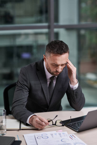 istock Overworked chief executive office with hand on temple feeling sick 1459028194