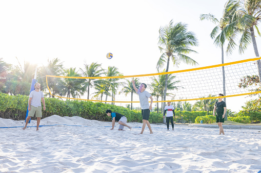 Group of people playing volleyball on the beach
