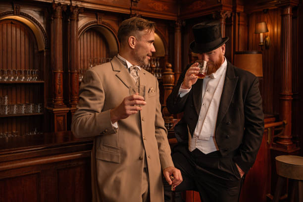 handsome victorian man in wig holding wine glass on black
