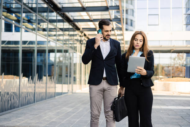 istock Businessman telephoning and his female colleague using tablet 1459030933