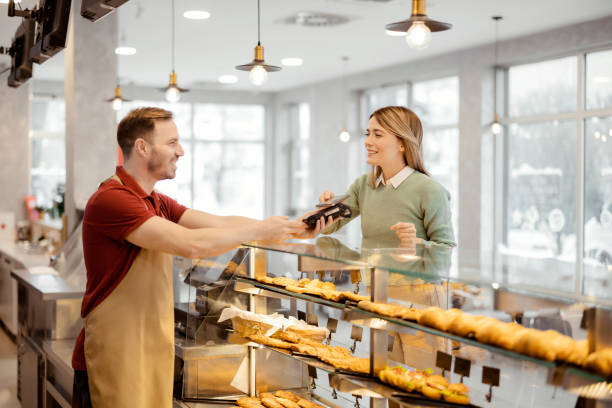 istock Female Customer Paying With Smartphone 1459033093