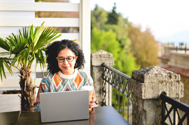 front view of a multiracial female working on computer on a sunny day remotly.