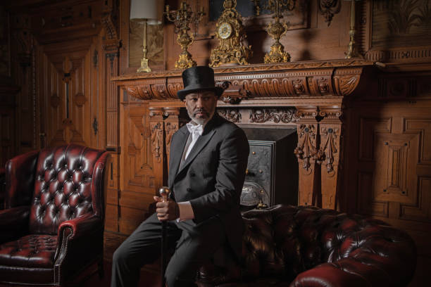 A handsome elegant 1920s style black gentleman in a luxury drawing room with a chesterfield sofa
