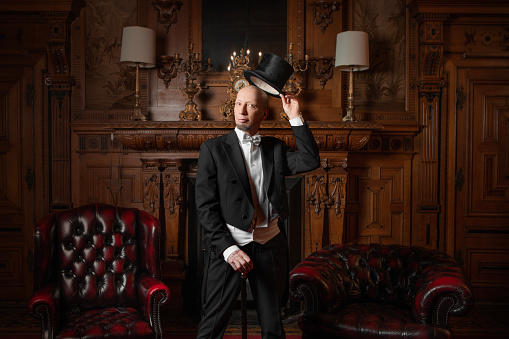 A handsome elegant 1920s style gentleman in a luxury stately home