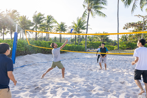 Group of people playing volleyball on the beach