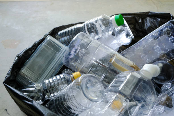 istock Close up view of plastic bottles containers collected in a black trash sorting bag on cement floor, to be recycled. Selective focus. Zero waste sustainability concept. 1459037182