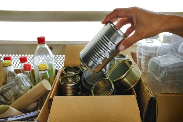 istock Man putting metal can into sorting boxes for recycling outside apartment flat. Zero waste sustainability concept. Recycling management - metal plastic glass bottles containers paper. Selective focus 1459037667