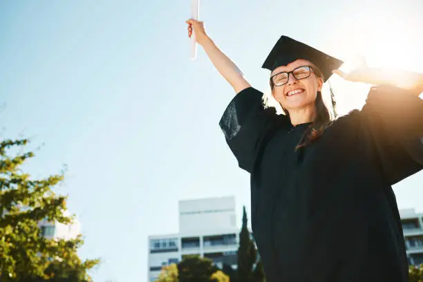 Photo of Woman, student and graduate for university achievement, scholarship or success for grades at the campus. Happy female in celebration for graduation, certificate or diploma for academic qualifications