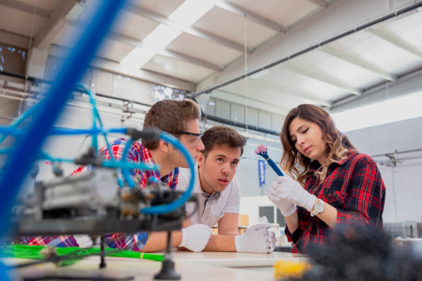 istock Young industry employees working with manufacturing equipment 1459042431