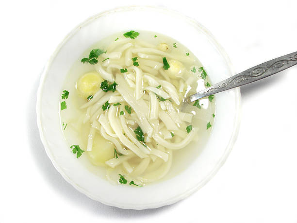 Caldo de frango quente com colher de sopa - fotografia de stock