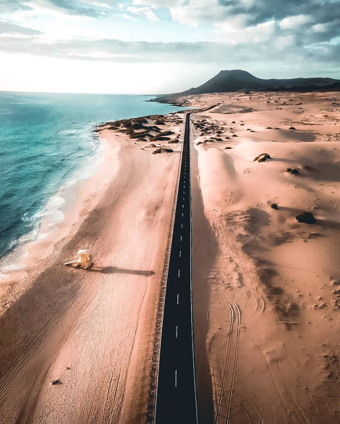 la strada delle dune di corralejo lungo l'oceano - fuerteventura foto e immagini stock