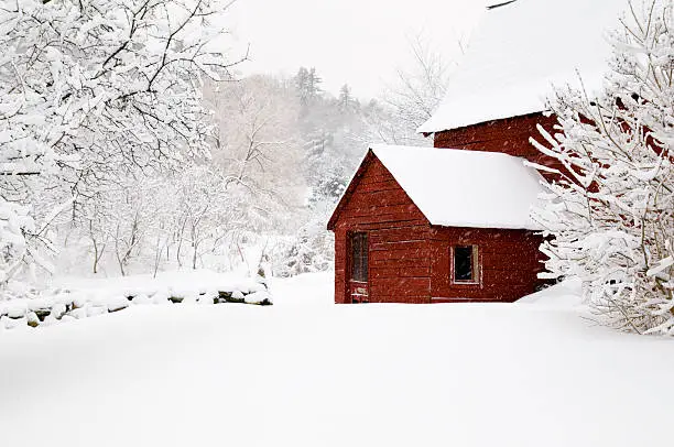 A red barn shown during a snow storm in Vermont