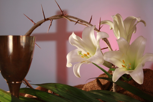 Representation of Holy Week. Palm fronds for Palm Sunday; communion chalice for Maundy Thursday; cross symbol,crown of thorns and cloth for Good Friday; and the white lilies representing Easter. Darker light on the left moving toward pinkish color on the right represents the movement toward Easter sunrise.