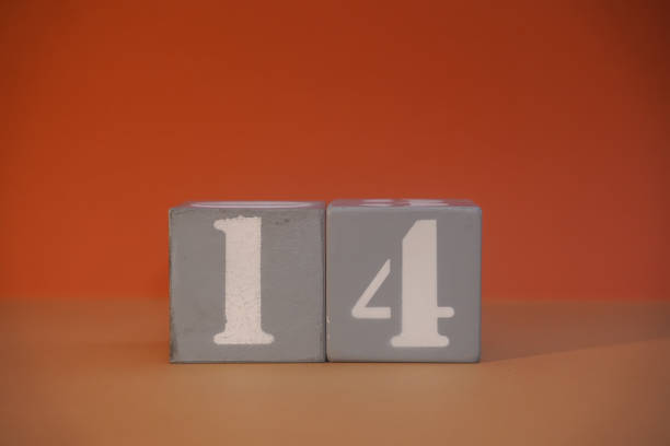 Number 14 on wooden grey cubes close-up. Concept of date time. Math concept. Copy space for text or event. White numbers 14 on building blocks, orange background. Educational cubes. Blurred background número 14 en cubos grises de madera en primer plano. concepto de fecha y hora. concepto matemático. copie el espacio para el texto o el evento. números blancos 14 en bloques de construcción, fondo naranja. cubos educativos. fondo borroso
