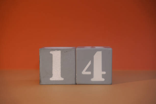 Number 14 on wooden grey cubes close-up. Concept of date time. Math concept. Copy space for text or event. White numbers 14 on building blocks, orange background. Educational cubes. Blurred background Number 14 on wooden grey cubes close-up. Concept of date time. Math concept. Copy space for text or event. White numbers 14 on building blocks, orange background. Educational cubes. Blurred background number 14 stock pictures, royalty-free photos & images