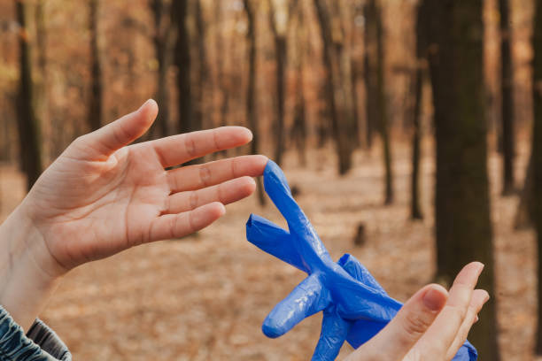 istock Hands take off rubber gloves in  forest 1459059933