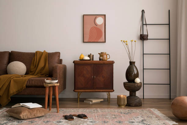 istock Interior design of living room interior with mock up poster frame, modern sofa, wooden commode, plaid, pillow, vase with dried flowers, pumpkin and personal accessories. Home decor. Template. 1459060122