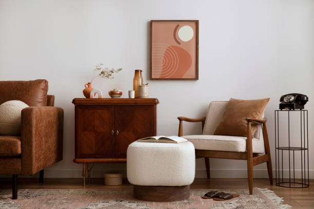 Vintage living room interior with mock up poster frame, wooden sideboard, boucle armchair, stylish white pouf, books, brown pillow, patterned carpet, books, slippers, vase with dried flowers and personal accessories. Home decor. Template. interior de la sala de estar vintage con marco de póster de maqueta, aparador de madera, sillón boucle, elegante puf blanco, libros, almohada marrón, alfombra estampada, libros, zapatillas, jarrón con flores secas y accesorios personales. decoración d