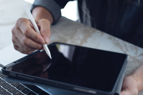 istock Close up of man hand using stylus pen signing on digital tablet screen, online working, e-signing, electronics, document, paperless office 1459061336