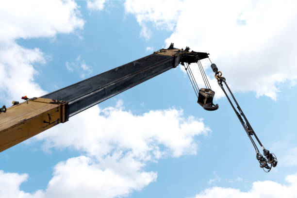 istock Yellow crane boom with hooks and blue sky background 1459061670