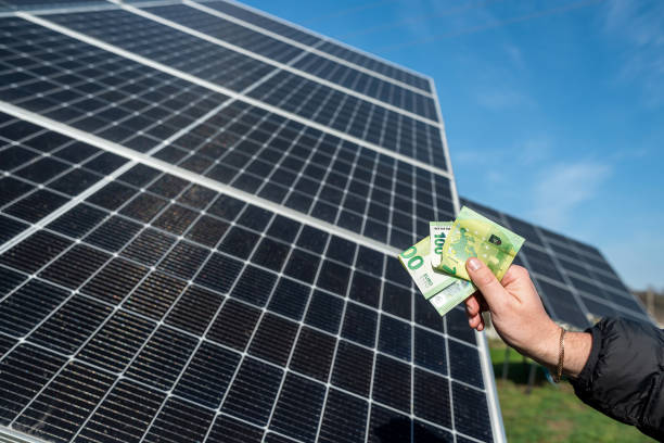istock young man's hand holds a euro for installing new solar energy efficient panels. 1459061805