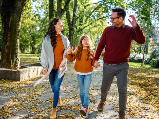 happy parents taking a walk with their little daughter - couple human pregnancy sunset walking imagens e fotografias de stock