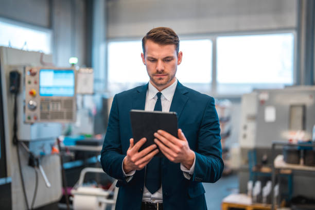 istock Serious Businessman Using A Digital Tablet While Working In A Manufacturing Plant 1459063165