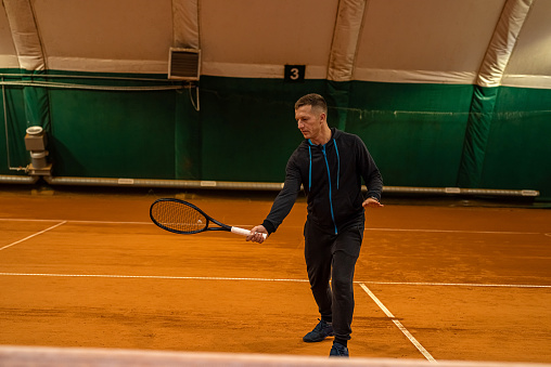 Portrait of a man hitting a tennis ball in a match on the court. sports tennis player tennis court. game