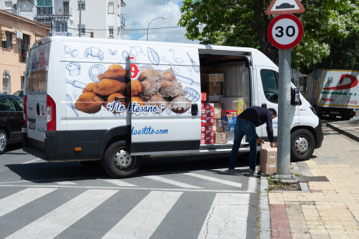 Plasencia, Spain - April 08, 2022: A assorted artisan sweets company delivery van parked on the street to deliver the purchase at home.