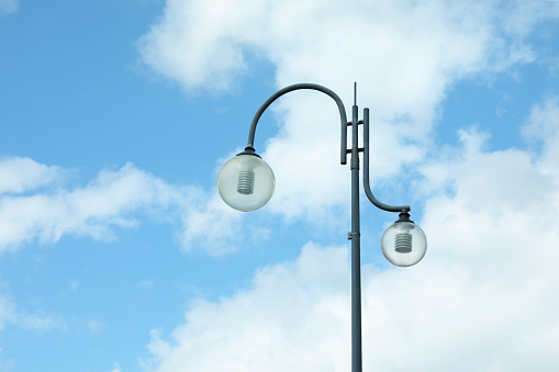 Beautiful street lamp with glass globes outdoors on sunny day. Space for text
