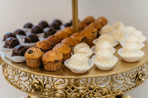 golden etagere with chocolates and muffins