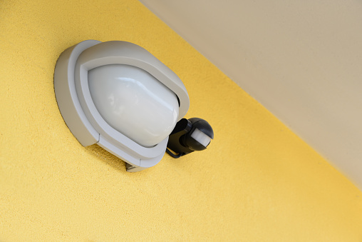 Modern street lamp on yellow wall of building