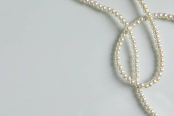 istock Elegant pearl necklace on white table, top view. Space for text 1459064696