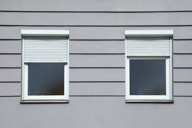 istock Wall of grey stone building with windows and rolling shutters 1459064731
