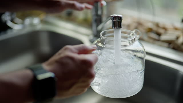 Pouring water into a kettle